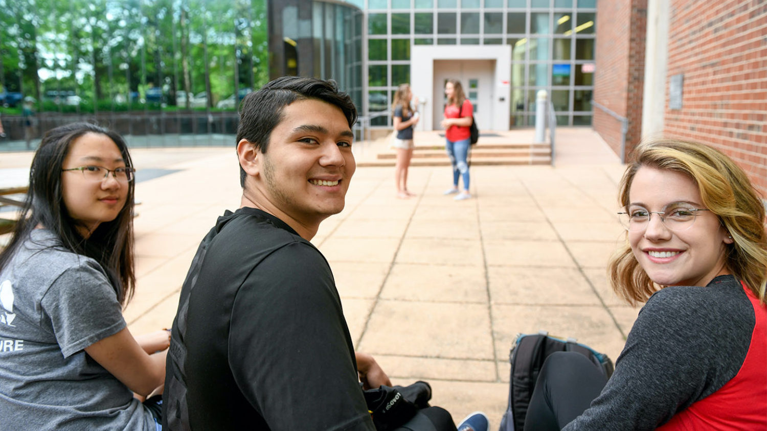 Three students sitting outside Jordan Hall at NC State's College of Natural Resources.