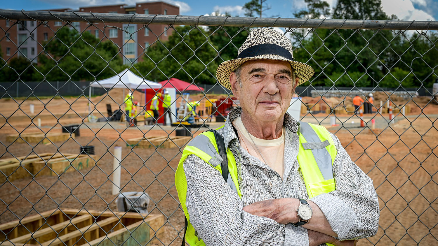 Artist Larry Bell poses in front of the installation of his artwork, Reds and Whites, in a plaza under construction outside the east entrance of Hunt Library.