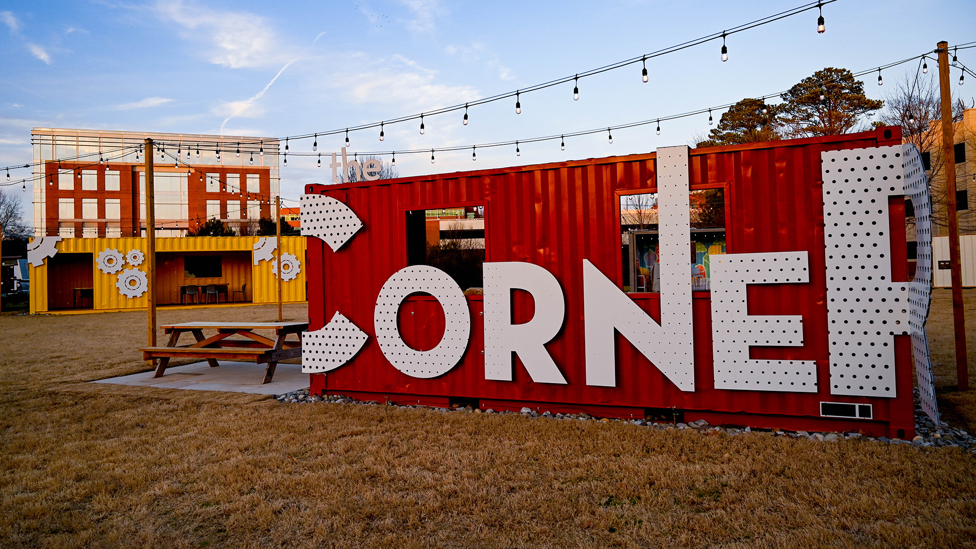 A red shipping container with the words "The Corner" affixed to the exterior.