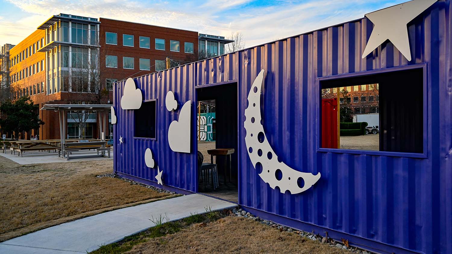 An exterior view of the indigo container in The Corner, covered in illustrations of the stars and moon.