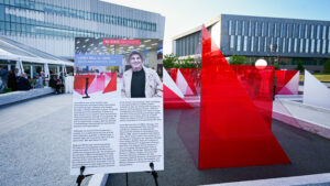 A view of the Reds and Whites art installation at the Susan Woodson Plaza on Centennial Campus, showing a poster honoring the world-renowned artist behind the artwork, Larry Bell.